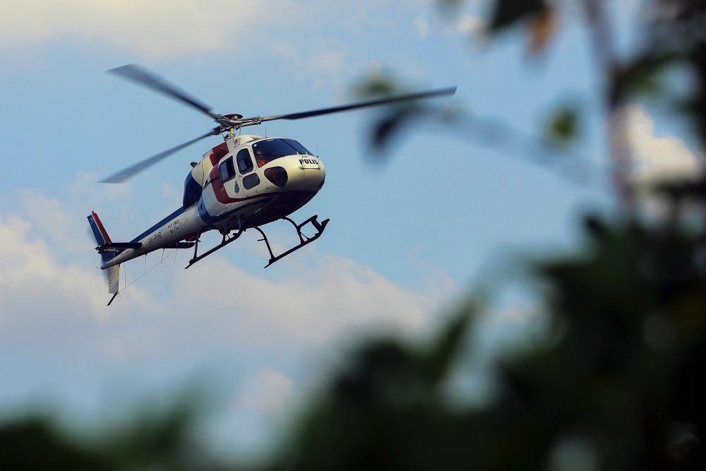 A helicopter carrying Negri Sembilan deputy police chief Che Zakaria Othman and district police chief Supt Mohd Nor Marzukee Besar is seen hovering over the Kampung Pantai airfield during a SAR operation on Aug 5, 2019. - Bernama