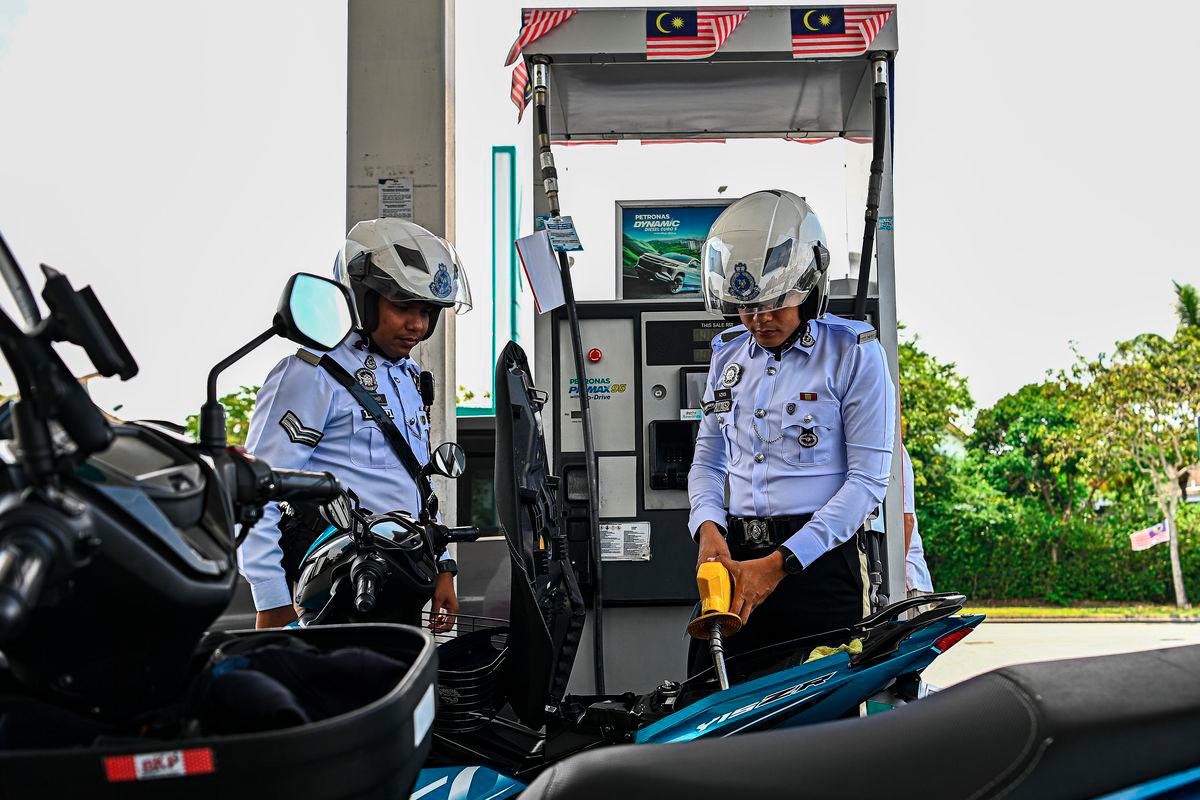 Traffic photographer from the Seremban District Police Headquarters (IPD), Azrin Abd Aziz (right), filled up with RON95 petrol at the Petronas S2 City Park station for RM1.99 per litre, compared to the market price of RM2.05 per litre, under the BUDI MADANI RON95 (BUDI95) initiative, which began today. – BERNAMA