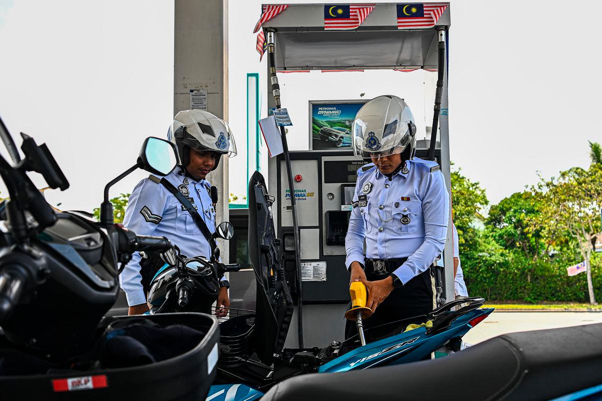 Jurugambar Trafik Ibu Pejabat Daerah (IPD) Seremban Azrin Abd Aziz (kanan) mengisi petrol RON95 di stesen Petronas S2 City Park pada harga RM1.99 seliter, berbanding harga pasaran RM2.05 seliter, menerusi inisiatif BUDI MADANI RON95 (BUDI95) yang bermula hari ini- BERNAMA