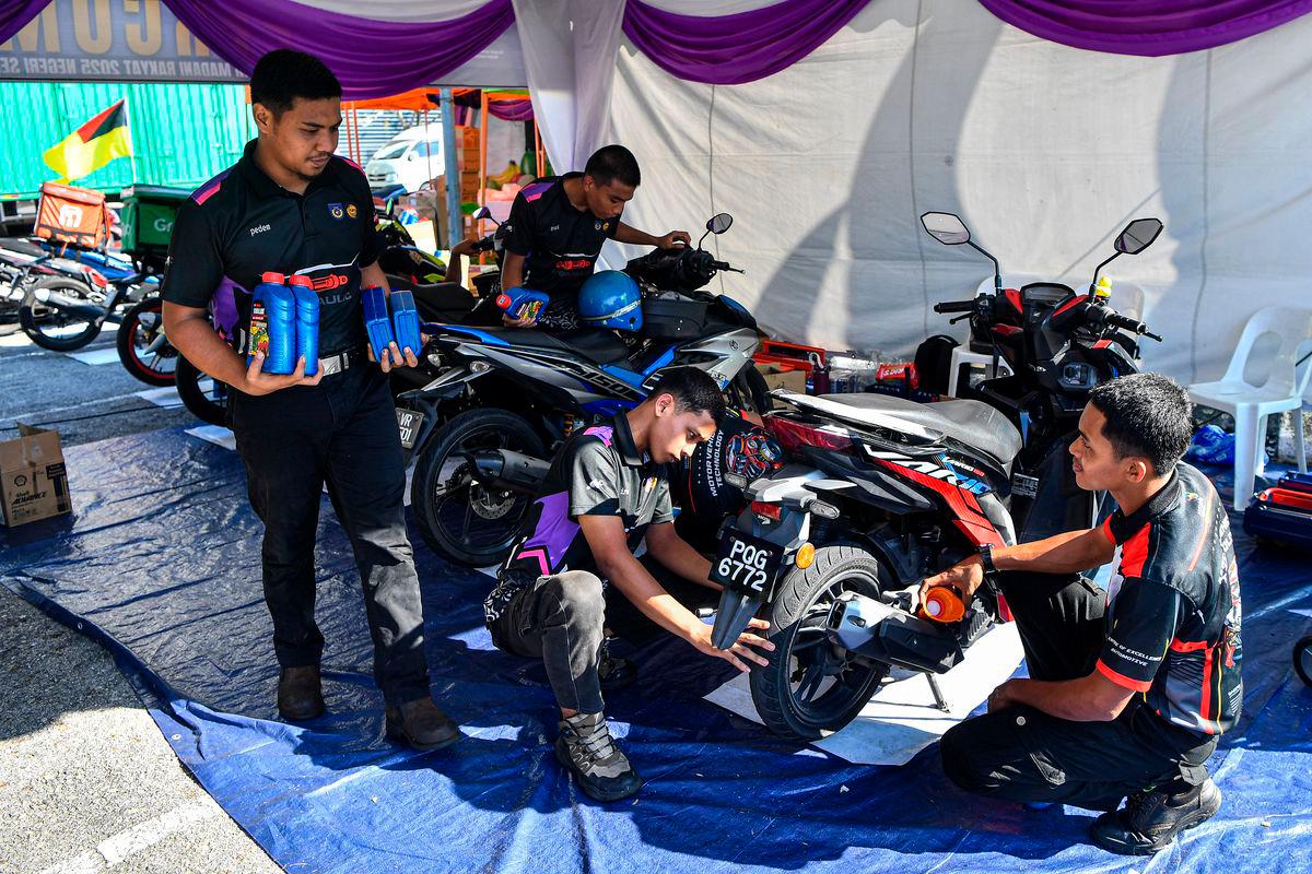 Para penuntut Institut Kemahiran Tinggi Belia Negara (IKTBN) Chembong melakukan khidmat penukaran minyak enjin serta pemeriksaan asas terhadap motosikal para pengunjung pada Program MADANI Rakyat (PMR) 2025 Negeri Sembilan di Dataran Nilai, hari ini - fotoBERNAMA