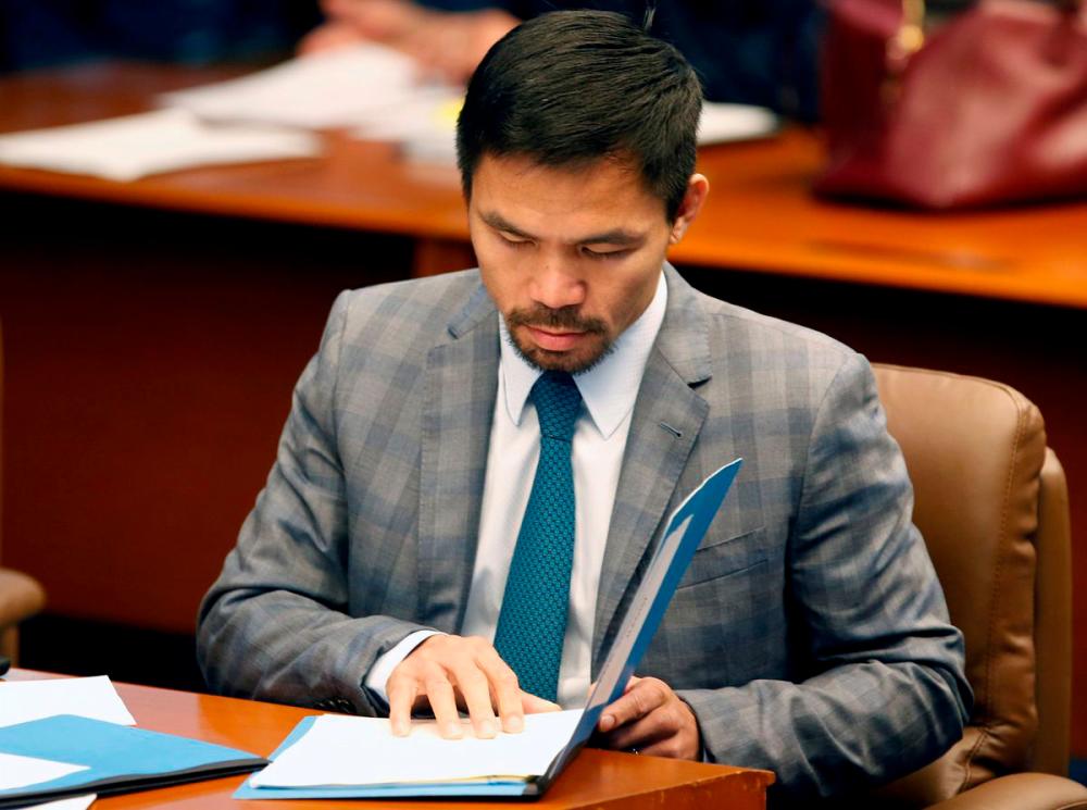 Philippine Senator and boxing champion Manny Pacquiao reads his briefing materials as he prepares for the Senate session in Pasay city, Metro Manila, Philippines September 20, 2016. Picture taken September 20, 2016. REUTERSPIX