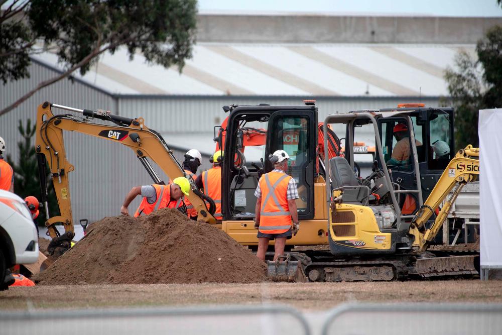 Workers dig grave sites at a cemetery in Christchurch on March 17, 2019 two days after a shooting incident at two mosques in the city. — AFP
