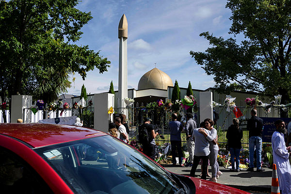 People gather outside the Al Noor Mosque after the main road that runs alongside it was opened to traffic in Christchurch on March 23, 2019. — AFP