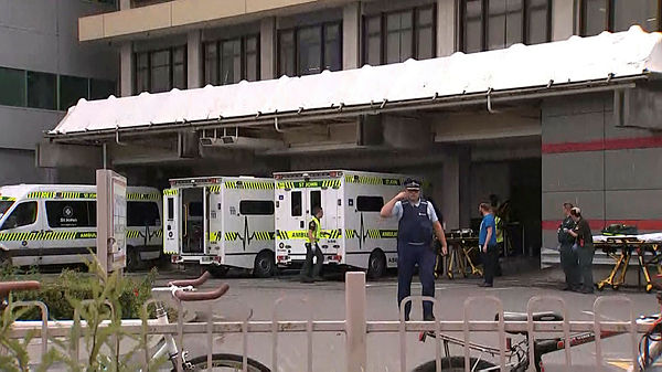 An image grab from TV New Zealand taken on March 15, 2019 shows a New Zealand police officer walking past ambulances at a hospital following a shooting at a mosque in Christchurch. — AFP