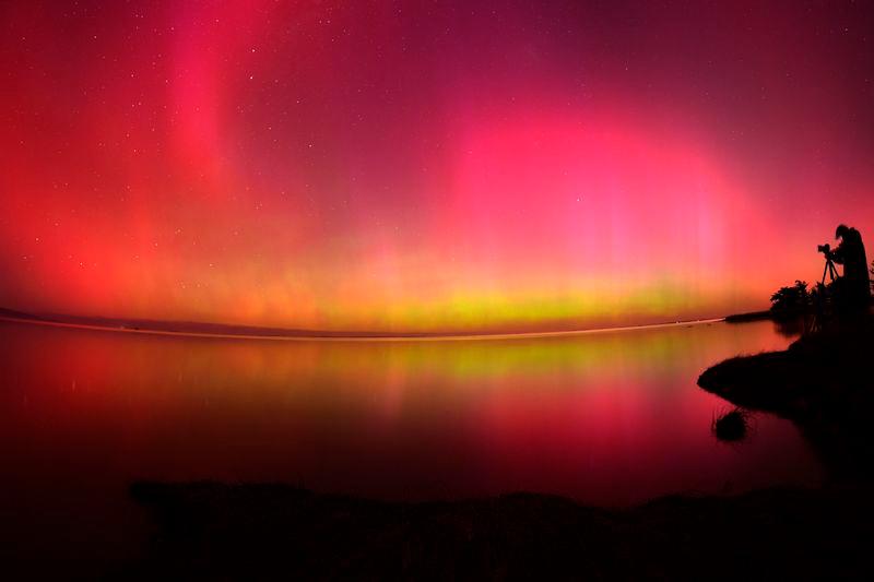 The Aurora Australis, also known as the Southern Lights, glow on the horizon over waters of Lake Ellesmere on the outskirts of Christchurch - AFPpix