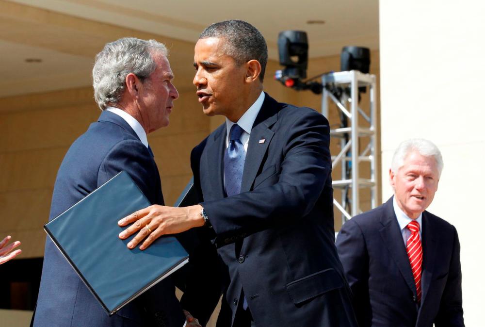 File Photo: U.S. President Barack Obama embraces former President George W. Bush following remarks at the dedication ceremony of the George W. Bush Presidential Center in Dallas, April 25, 2013. Former president Bill Clinton is pictured at right. REUTERSpix