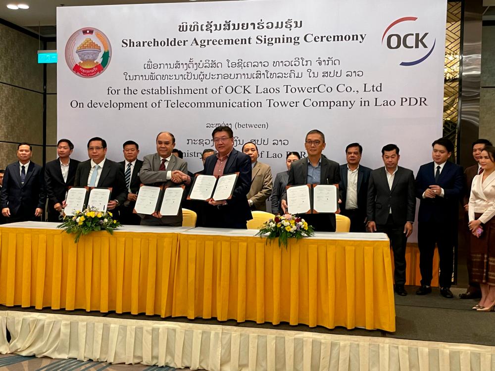 (Front, from left): Laos Ministry of Technology and Communication (Telecommunication Regulation Authority) director-general Soudchay Lorlonesy, Laos Ministry of Finance (State-Owned Enterprises Reform and Insurance department) Dr. Sonephet Inthavong, Ooi, OCK group CEO David Low Hock Keong at the signing ceremony.