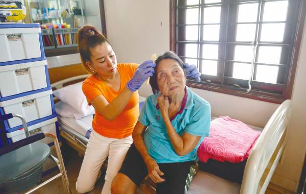 Wong helps to groom a resident as personal hygiene is important for her well-being.