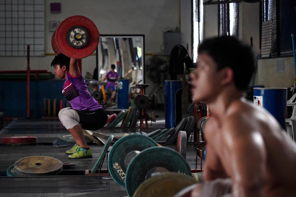 This photo taken on July 18, 2019 shows a weightlifter practising jerks during a training session at the national team's training camp in the northern province of Chiang Mai. — AFP