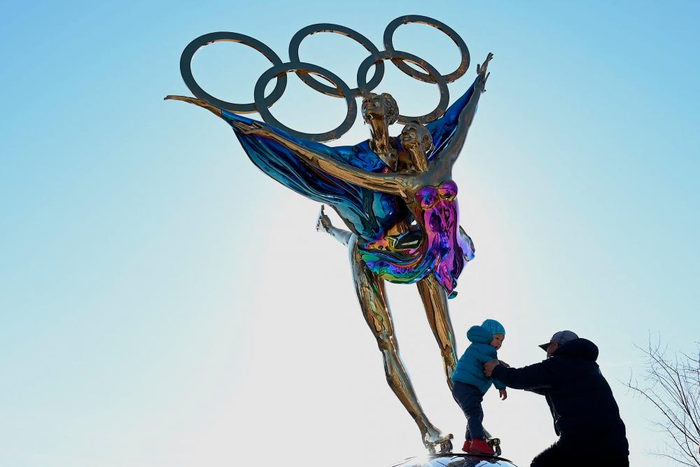 A child stands on a statue with the Olympic Rings titled Dating With the Winter Olympics by Huang Jian, near the headquarters of the Beijing Organizing Committee in Shougang Park, one of the sites for the Beijing 2022 Winter Olympics, in Beijing on December 7, 2021. AFPpix