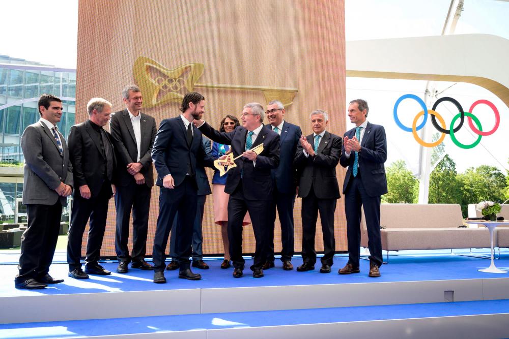 International Olympic Committee (IOC) president Thomas Bach (C) reacts and thanks as he receives the new key of the Olympic house, the new IOC headquarters, from senior architect Jan Ammundsen (4th L) during the inauguration ceremony, in Lausanne, on June 23, 2019 ahead of the decision on 2026 Winter Games host. — AFP