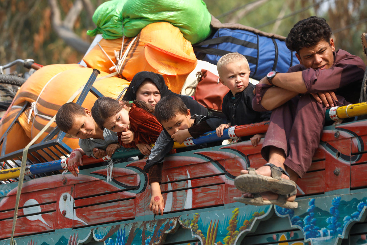 Afghan refugee children sit on a truck loaded with belongings as they along with their families prepare to return home, after Pakistan gives the last warning to undocumented immigrants to leave, outside the United Nations High Commissioner for Refugees (UNHCR) repatriation centres in Azakhel town in Nowshera, Pakistan October 30, 2023. - REUTERS