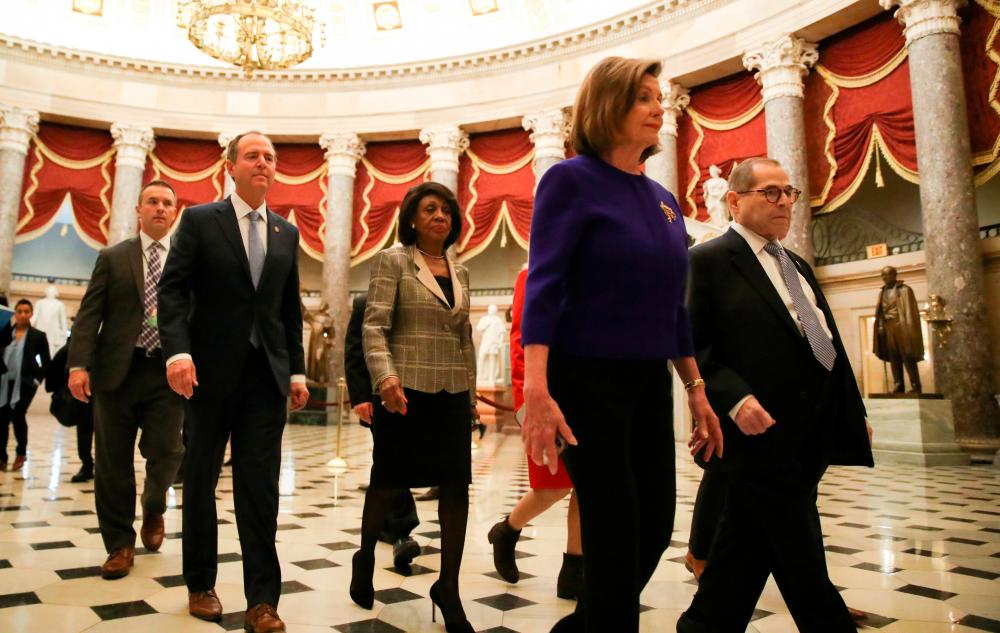 Speaker of the House Nancy Pelosi leads Judiciary Chairman Jerrold Nadler (D-NY), House Financial Services Chairwoman Maxine Waters (D-CA) and House Intelligence Chairman Adam Schiff (D-CA) and other Democratic committee chairs through statuary hall to a news conference to announce artiicles of impeachment against US President Donald Trump on Capitol Hill in Washington, Dec 10, 2019. - Reuters