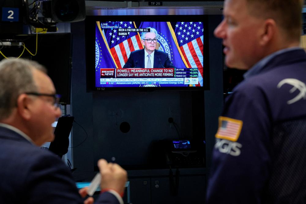 Traders at the New York Stock Exchange react as a screen shows Powell delivering remarks on Wednesday, May 3, 2023. – Reuterspic