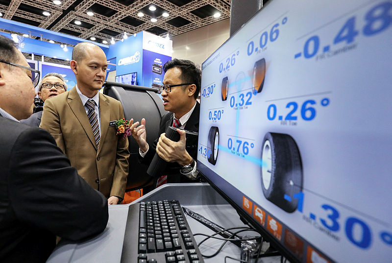 Deputy International Trade and Industry Minister Dr Ong Kian Ming (C) listens to a briefing during the 11th Automechanika Kuala Lumpur, on March 21, 2019. — Sunpix by Amirul Syafiq Mohd Din