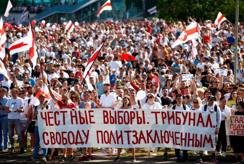 Demonstrators take part in a protest against the presidential election results demanding the resignation of Belarusian President Alexander Lukashenko and the release of political prisoners, in Minsk, Belarus August 16, 2020. The banner reads: Fair elections. Tribunal. Freedom for political prisoners. - Reuters