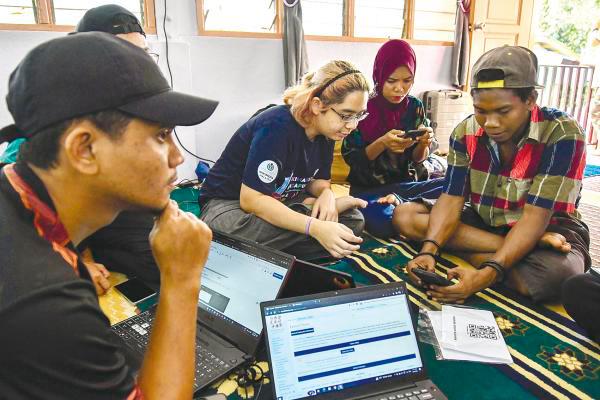 Wikimedia Malaysia volunteers jot down words and sentences used by the Orang Asli people of the Mendriq group in Kampung Kuala Lah, near Gua Musang. – BERNAMAPIX