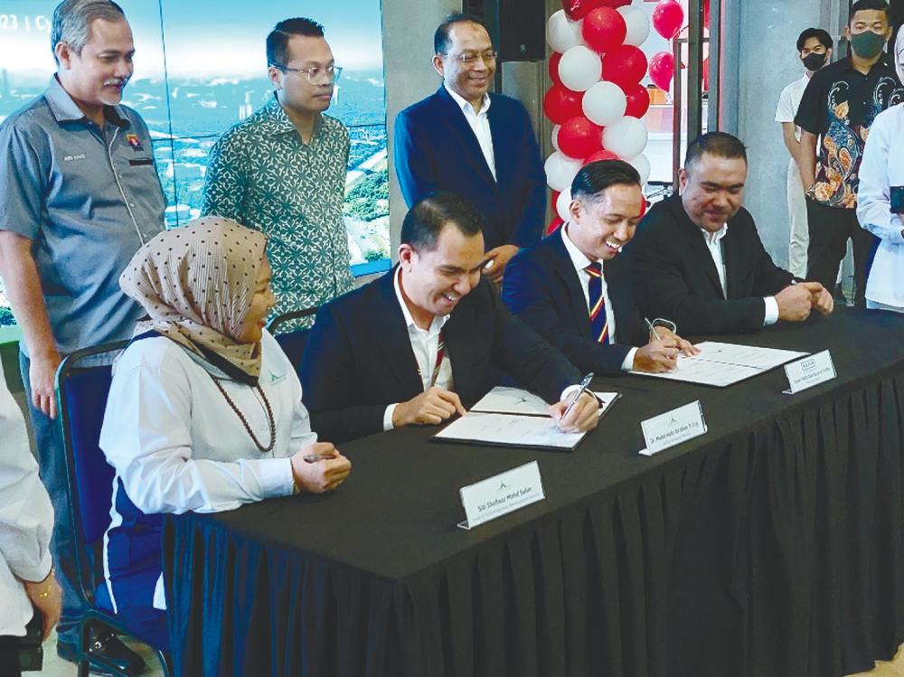 Nik Nazmi (standing, centre) witnessing the signing of an MoU between Cyberview and Roda Emas Industries.