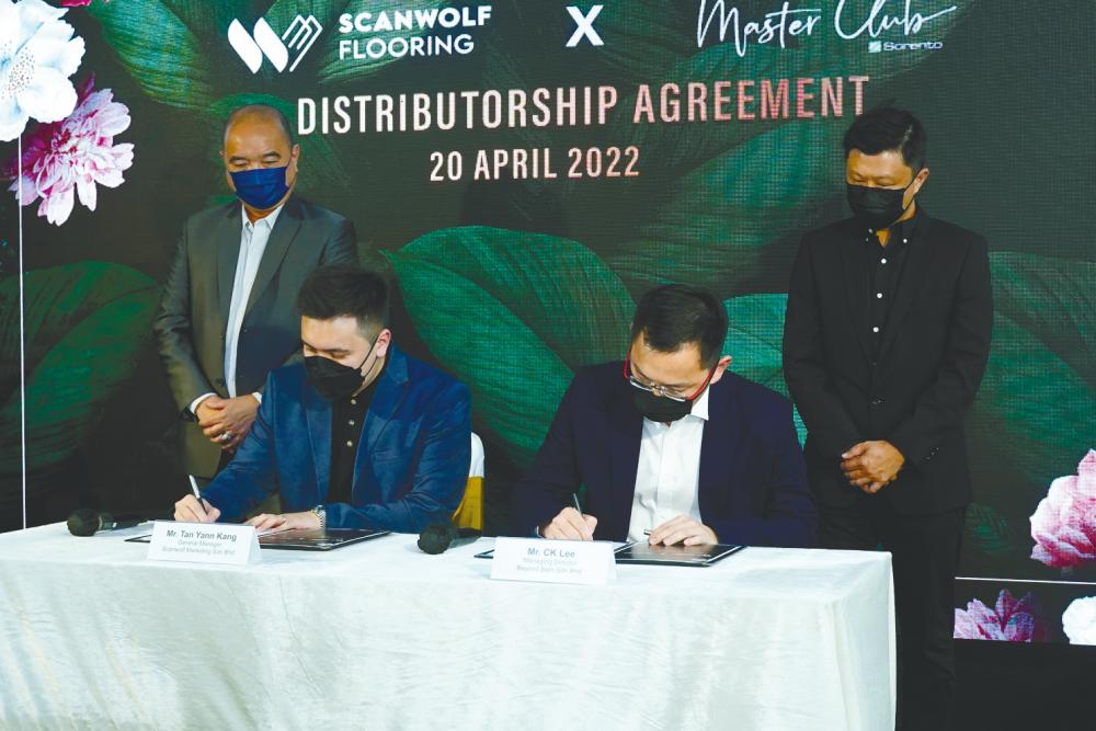 Tan (left) and Lee signing the distributorship agreement.