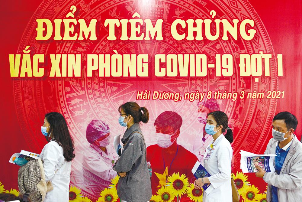 Health workers waiting to receive their Covid-19 vaccine in a hospital in Vietnam. Currently, 19 southern localities in the country have implemented a lockdown until Aug 16. – REUTERSPIX