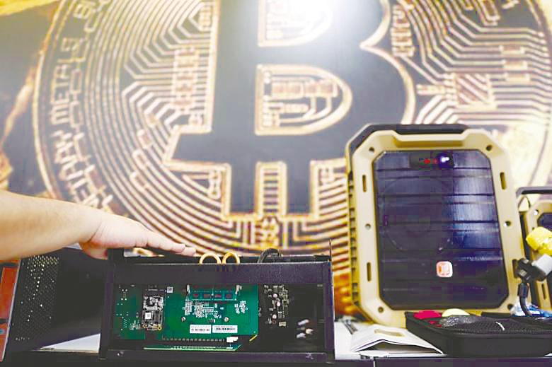 A cryptocurrency mining computer is seen in front of a bitcoin logo. Bitcoin hit its peak of over US$20,000 in late 2017, followed by a plunge in early 2018 to a low of US$3,339. – REUTERSPIX