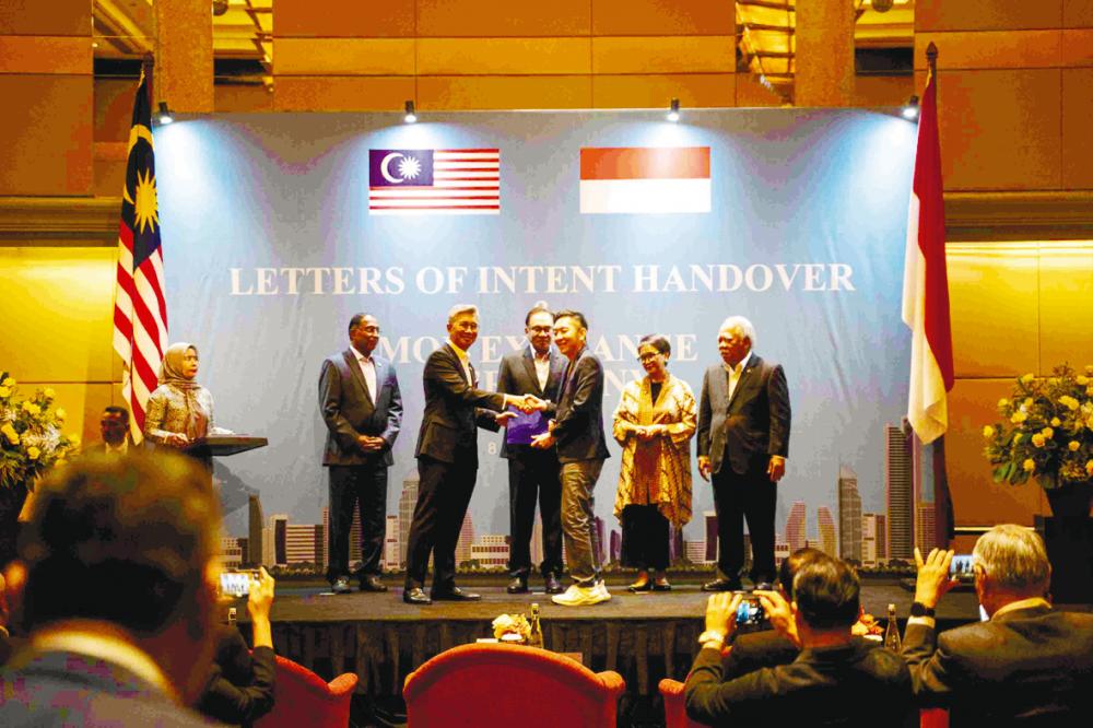 Cheng (third from right) handing over the LOI to Tengku Zafrul, witnessed by Anwar (centre) and Malaysian and Indonesian ministers.