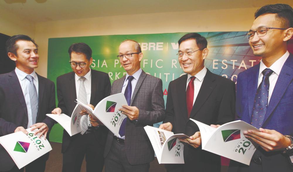 From left: Tan, CBRE-WTW director Peh Seng Yee, Foo, director Cornelius Koh and Ungku Iskandar with the CBRE-WTW market outlook report. - ZULFKIFLI ERSAL/THESUN