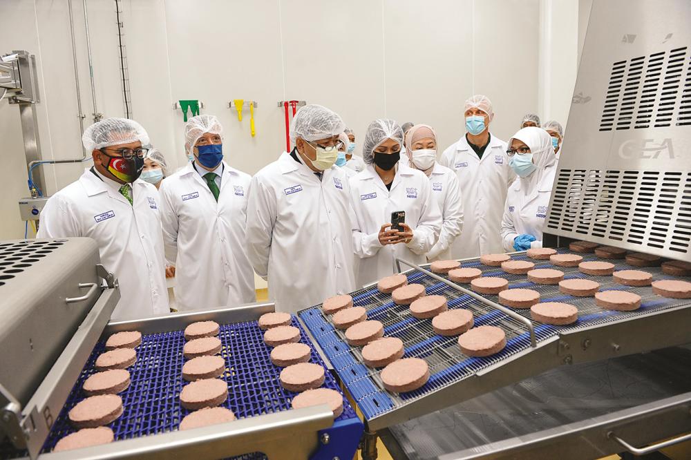 From left: Selangor Menteri Besar Datuk Seri Amirudin Shari, Aranols, Sultan Selangor Sultan Sharafuddin Idris Shah and Tengku Permaisuri Selangor Tengku Permaisuri Norashikin observing the production line for the plant-based Sensational Burger patty.