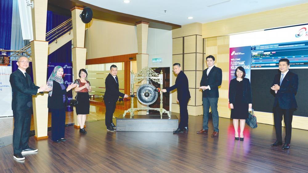 Tan (fourth from left) and Flexidynamic executive director Liew Heng Wei striking the gong. Looking on are (from left) M&amp;A Securities Sdn Bhd head of corporate finance Gary Ting, Flexidynamic director Noor Zaliza Yati Yahya, chairperson Phang Sze Fui, director Chong Kai Feng, executive director Lion Suk Chin, and M&amp;A Securities managing director of corporate finance Datuk Bill Tan.