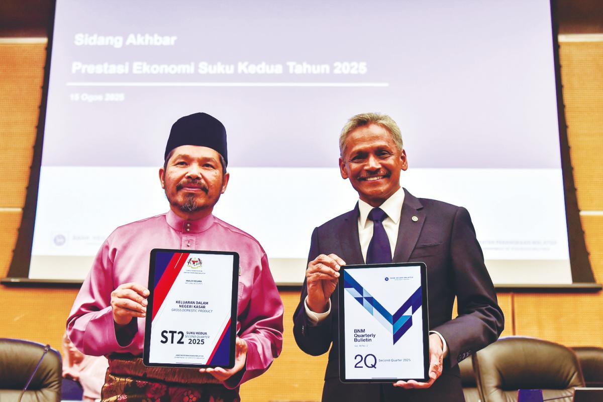 Abdul Rasheed (right) and Chief Statistician of Malaysia Datuk Seri Dr Mohd Uzir Mahidin displaying copies of a report on the country’s second quarter economic performance at a press conference in Kuala Lumpur today. – Bernamapic
