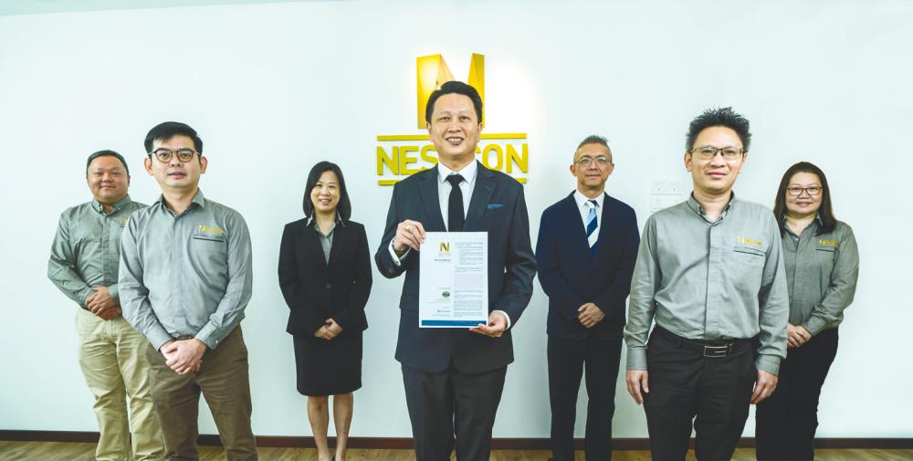 Lim (centre) with Nestcon finance director Lim Joo Seng (third from left), M&amp;A Securities head of corporate finance Gary Ting (third from right), and Nestcon’s key senior management team. Picture was taken before the implementation of the full MCO.