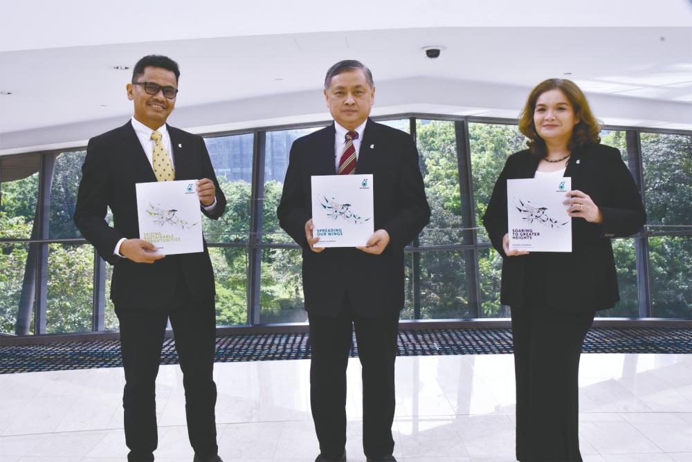 From left: Aziz, Petronas Gas chairman Adnan Zainol Abidin and Shariza after the AGM yesterday.