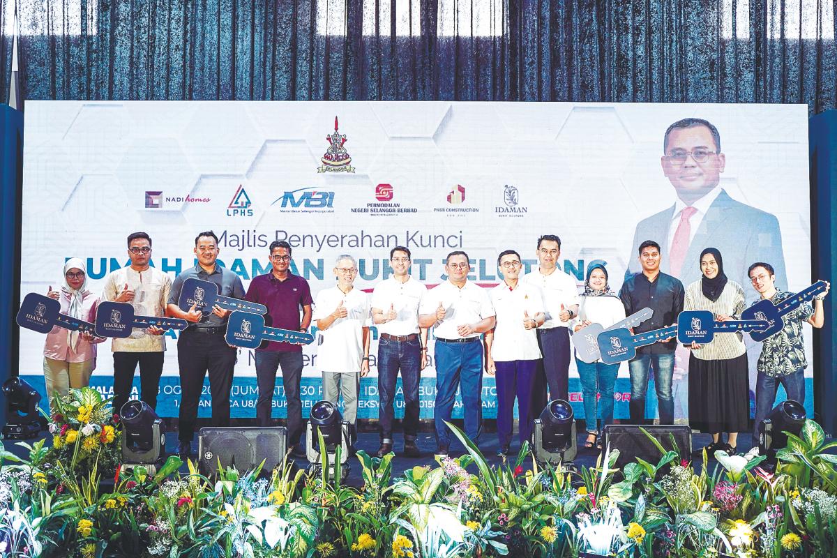 Amirudin and recipients at the key handover ceremony for the Idaman Bukit Jelutong condominium today. – Bernamapic
