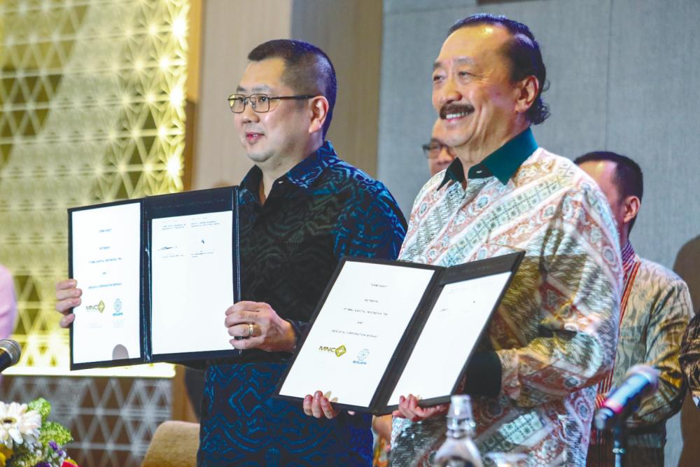 Tanoesoedibjo (left) and Tan displaying the signed documents.