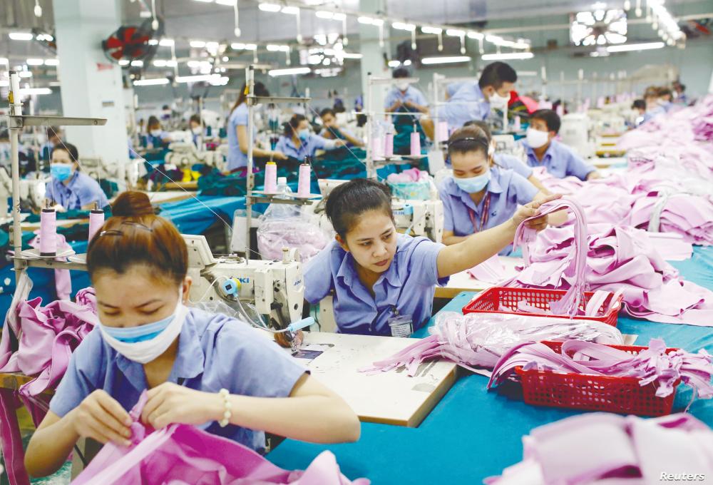 Workers on a production line in a garment factory in Hanoi, Vietnam. The Malaysian textile and apparel industry is expected to face competition from lower-cost producers in the RCEP region such as Vietnam. – REUTERSPIX