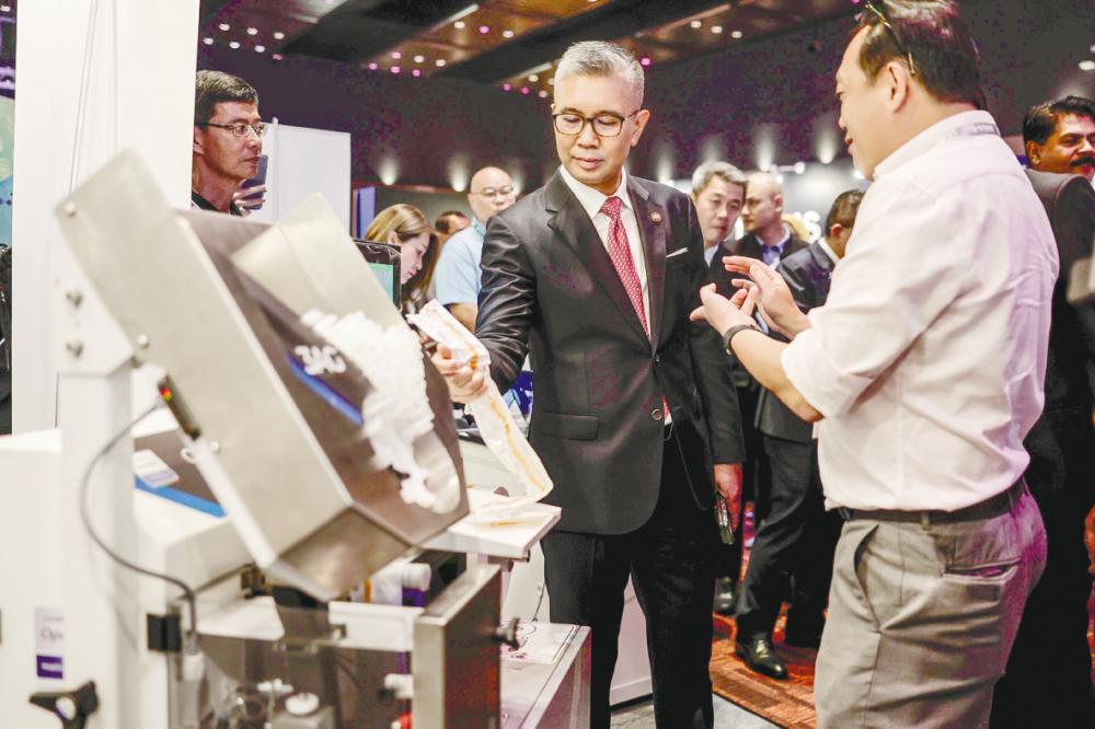 Tengku Zafrul viewing one of the exhibits on display at the launch of Malaysia External Trade Development Corporation’s Digital Trade Platform. – Bernamapic