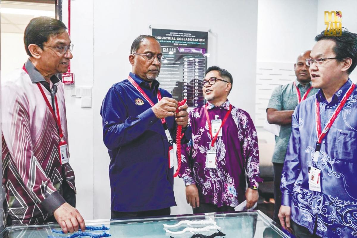 Zambry taking a closer look at an iten during his visit to the newly established USM-Sandisk CiA Lab.