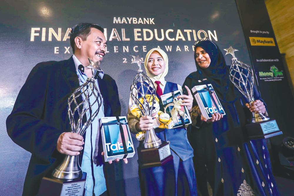 From left: SK Kerubong headmaster Hazman Dolah, Nur Khairina and Jamilah during the awards ceremony in Kuala Lumpur yesterday. – Adib Rawi Yahya/theSun