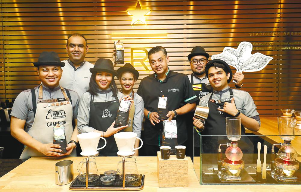 Quays (third from right) with staff after unveiling the first Starbucks Reserve outlet at the Gurney Plaza. – MASRY CHE AINI/THESUN