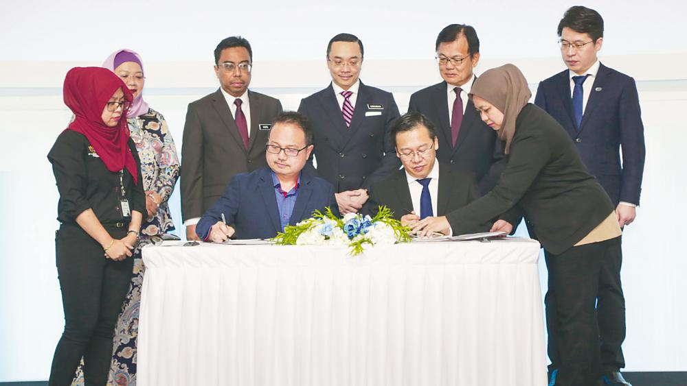 Madani (left) and Zhou signing the MoU on the next-generation vehicle hub in Cyberjaya today.
