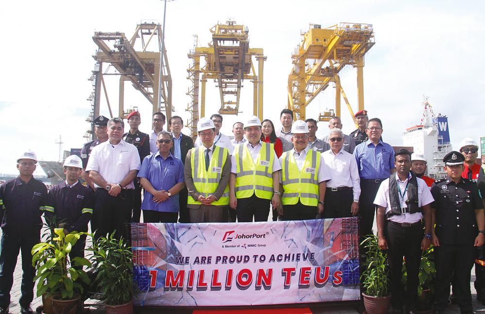 Loke (centre) and Che Khalib (seventh from left) together with employees of Johor Port posing for the press after the historical event in Pasir Gudang today. – BERNAMAPIX