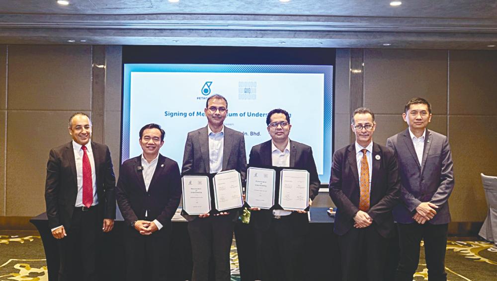 Petronas head of data science Dr Sambasivam Rajamani (third from left) and AIQ chief technology officer Saravan Kumar Penubarthi (third from right) at the MoU signing ceremony. With them are (from left) AIQ business development director Ghalib Brahimi, Aadrin, AIQ senior vice president of commercial and business development Dr Ahmed Salem and Petronas Digital Sdn Bhd CEO Phuah Aik Chong. – Petronas pic