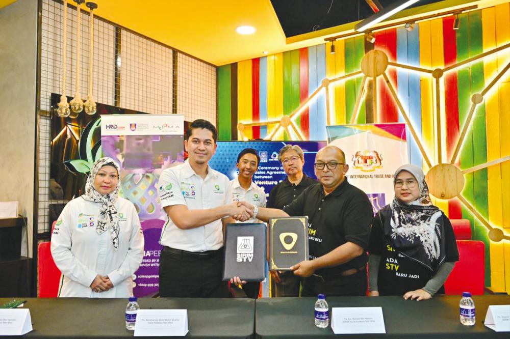 Ajmain Kasim (second from right) exchanging documents with Anuar Hanizan, witnessed by Ahmad Sabirin (third from right) and Abdul Qy’yum Jalal.