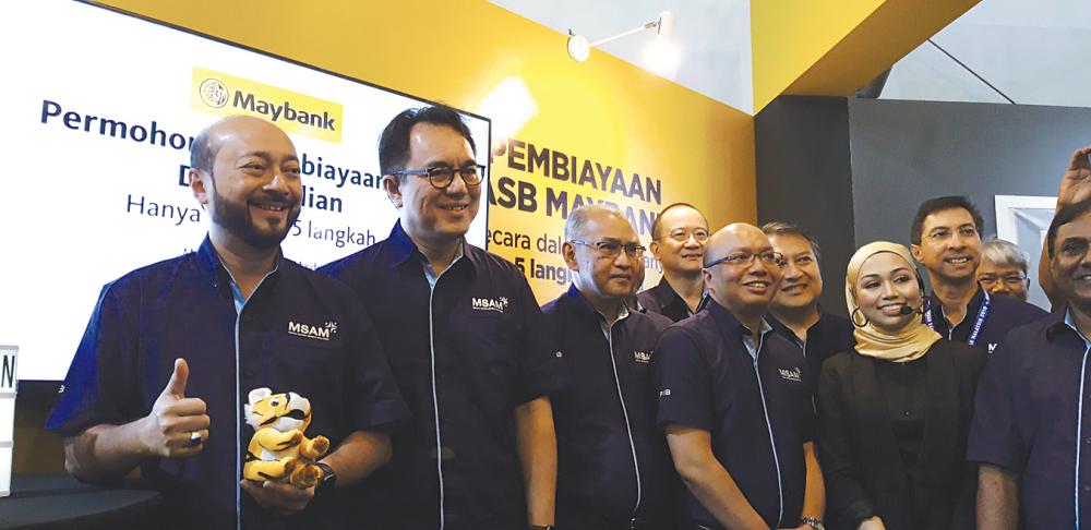 Kedah Mentri Besar Datuk Seri Mukhriz Mahathir (left) launching the Maybank ASB online financing service at MSAM 2019 yesterday. Next to him is Maybank group president and CEO Datuk Abdul Farid Alias.