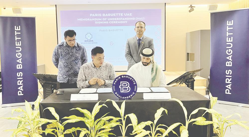 Quays (left) and Samaya Food Investments CEO Amer Al Ahbabi signing the memorandum of understanding, witnessed by Berjaya Food International director Luis Daniel.