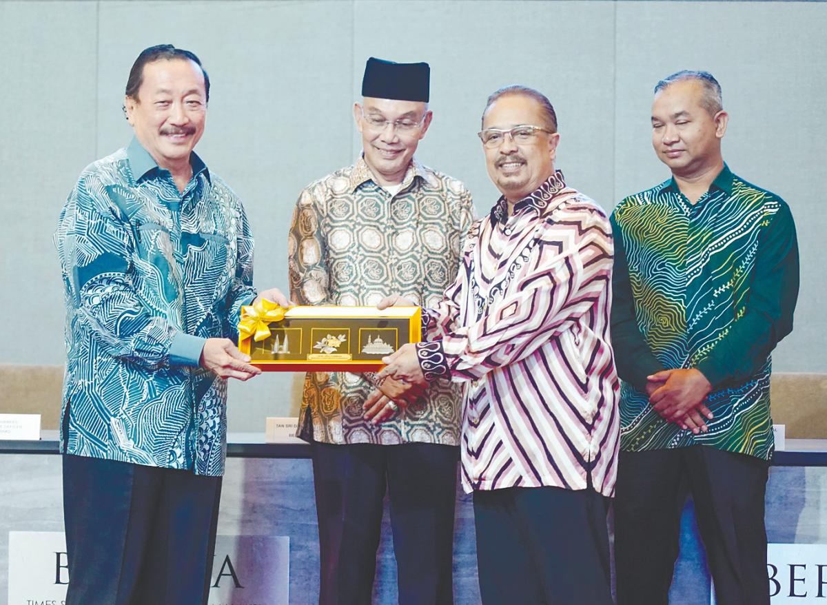 Tan (left) presenting a token of appreciation to Syed Tajul Arif after the MoU signing between Berjaya Land and Impianan Utara, witnessed by Mohd Shukri Ramli (second left) and MBI Perlis acting CEO Ahmad Hishamudin Johari. – AMIRUL SYAFIQ/THESUN