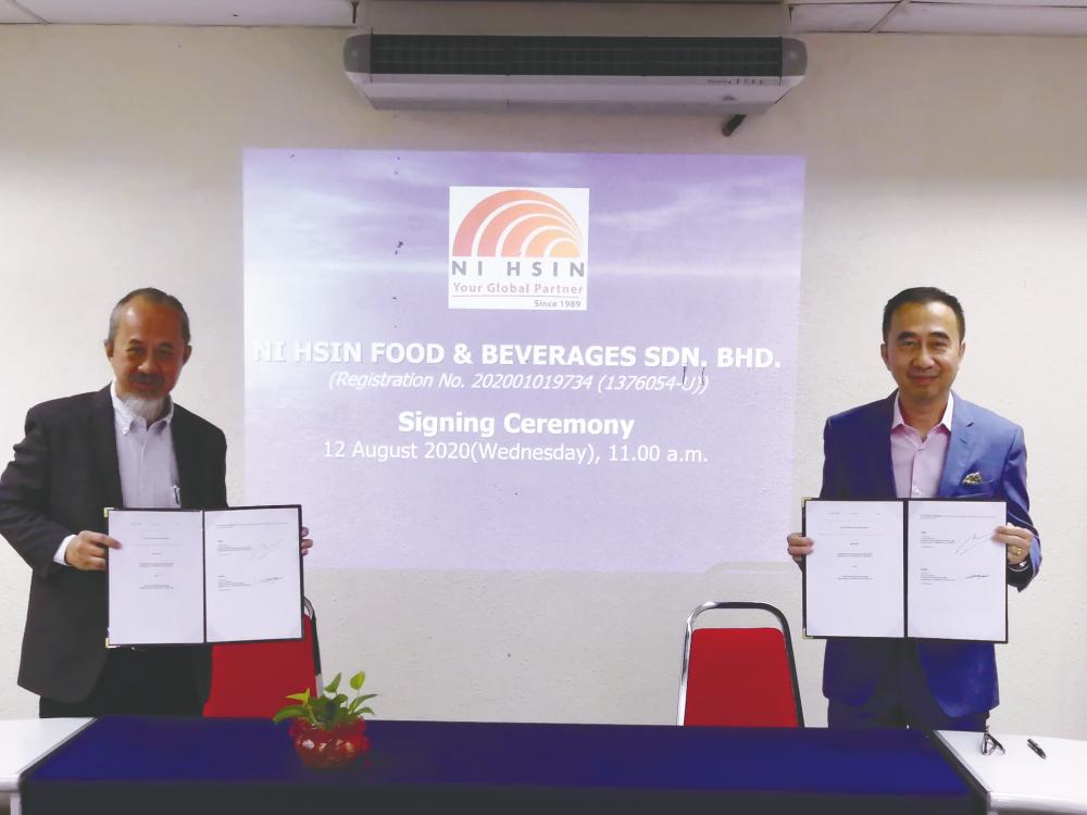 Fiatec executive director Dr Loh Kai Kwong (left) and Khoo at the signing ceremony.