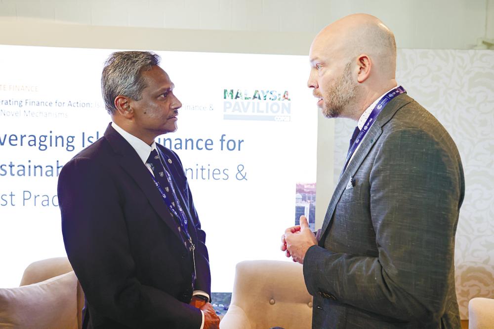 Abdul Rasheed (left) chatting with Islamic Development Bank lead climate change specialist Dr Bradley Hiller at a forum on Leveraging Islamic Finance for Sustainability: Opportunities and Best Practices held at the Malaysia Pavilion during COP28 in Dubai today. – Bernamapic