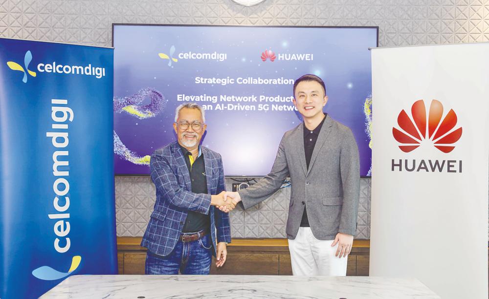 Idham and Sun formalising the collaboration between CelcomDigi and Huawei Malaysia.