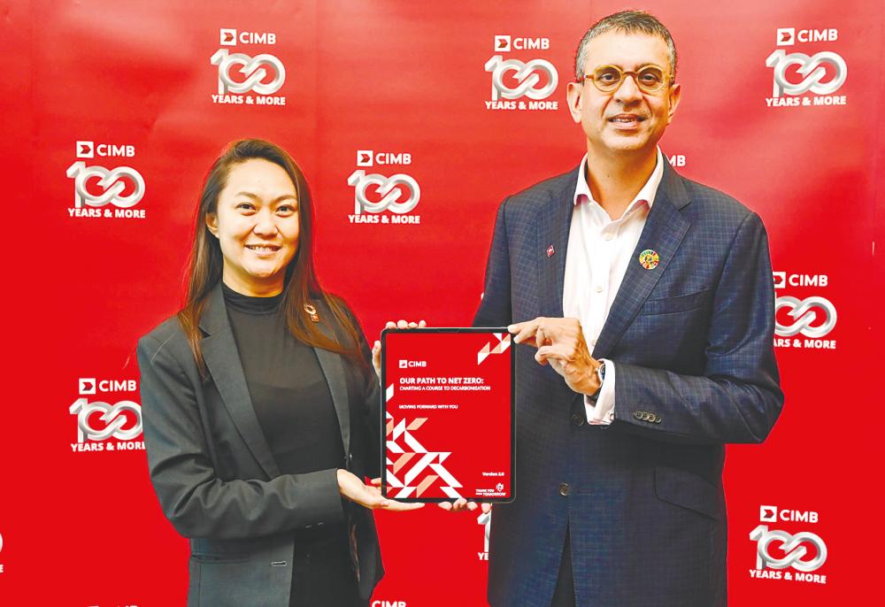 CIMB Group chief sustainability officer Luanne Sieh (left) and Gurdip presenting the white paper detailing its decarbonisation plans.